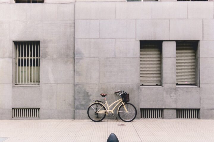 bicycle parked against concrete building in