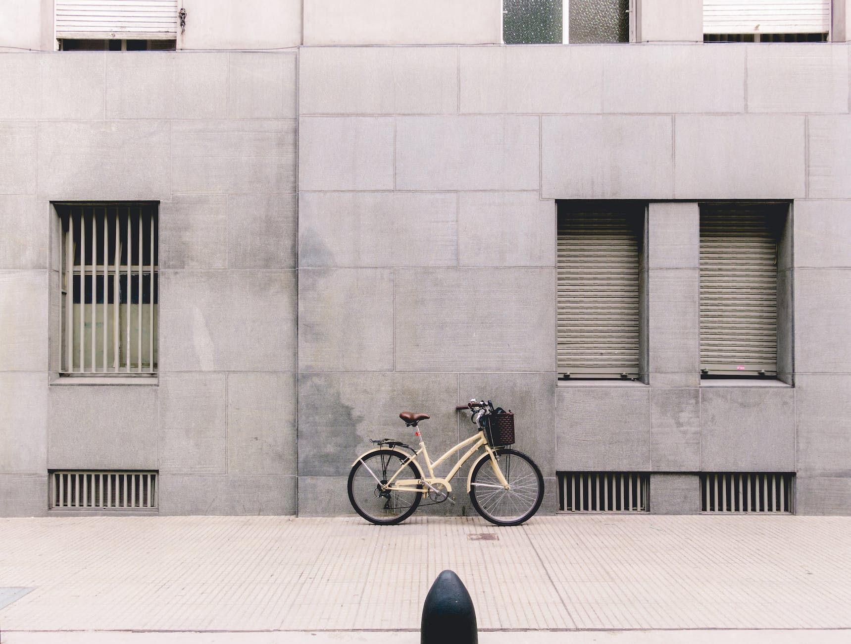 bicycle parked against concrete building in