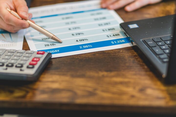 a close up shot of an agent pointing rates with a ballpen