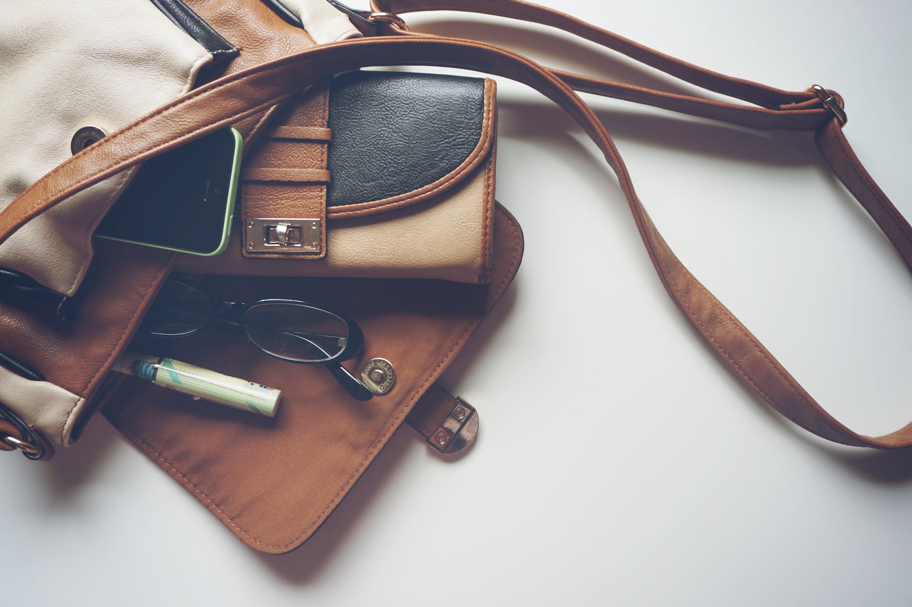 brown leather crossbody bag with eyeglasses