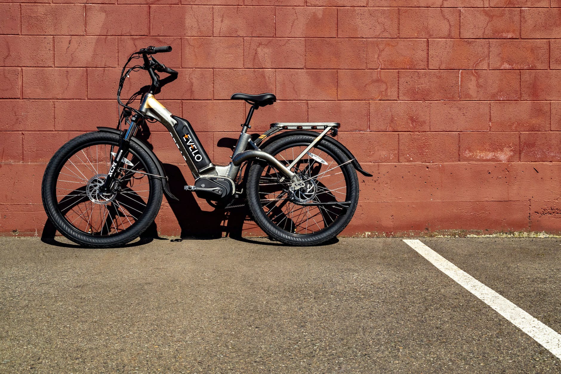 a bike parked beside brick wall