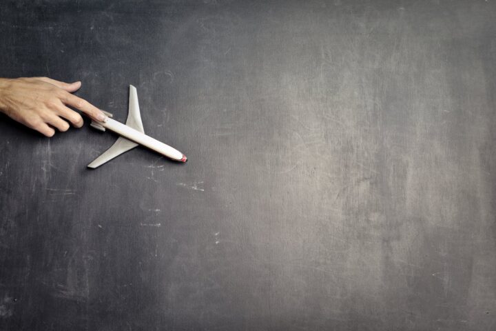 anonymous person with miniature airplane on chalkboard