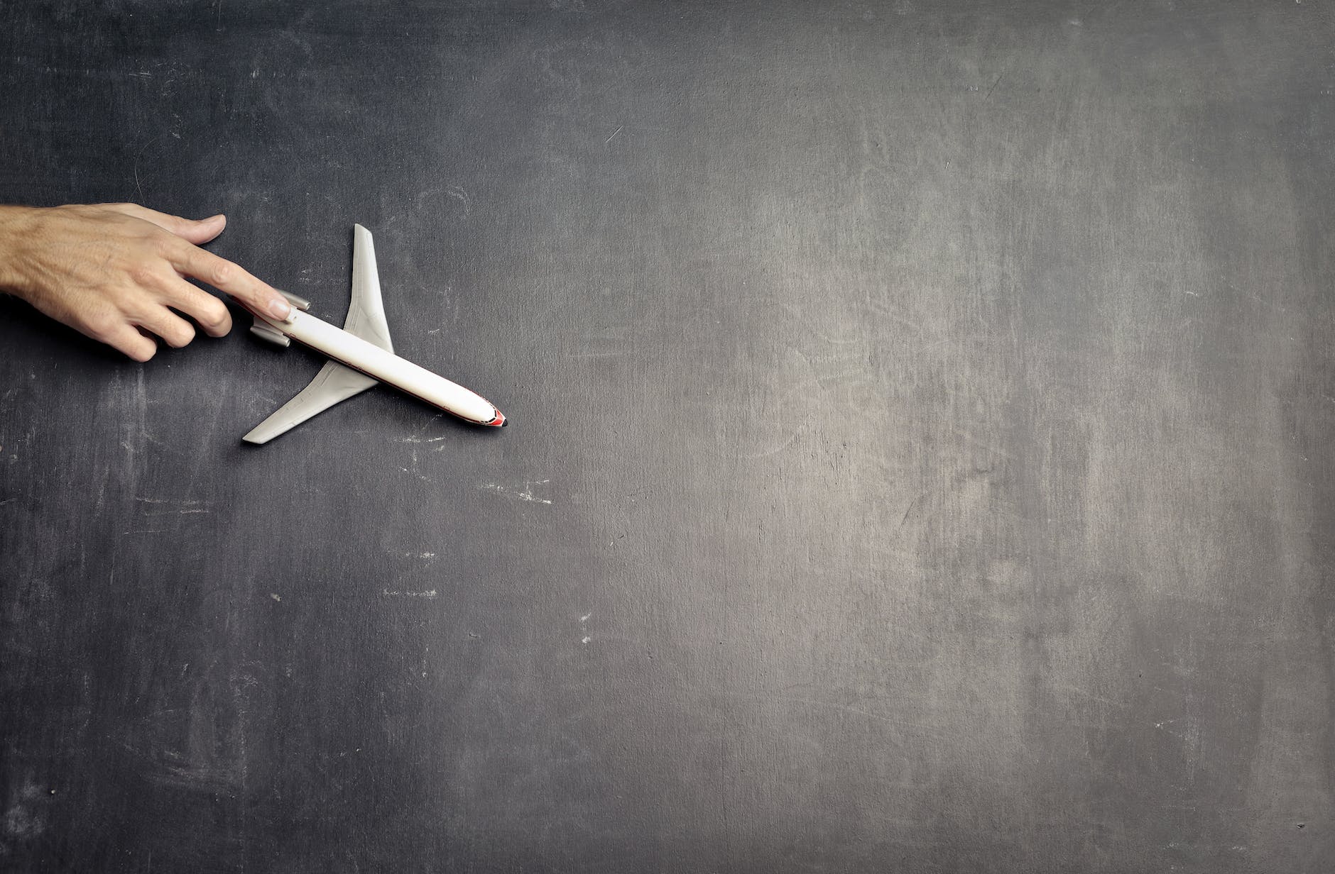 anonymous person with miniature airplane on chalkboard