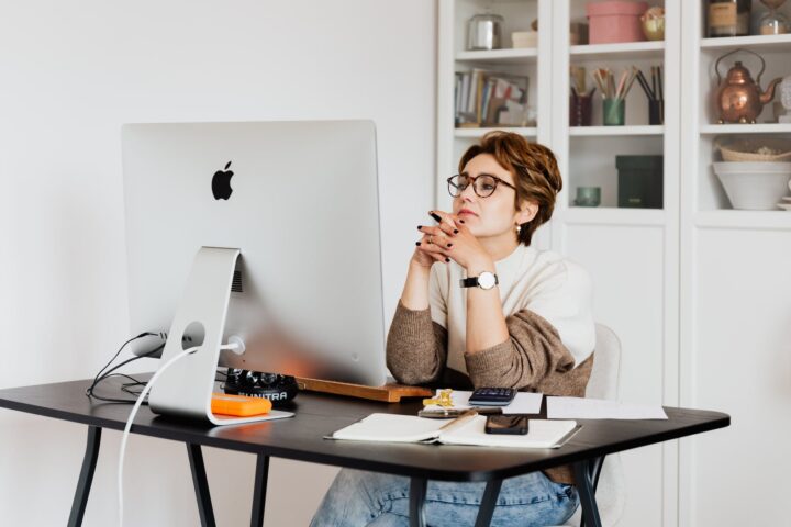 focused female employee reading information on computer in office