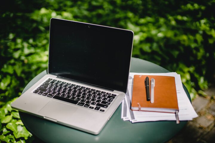 laptop and diary on table in garden