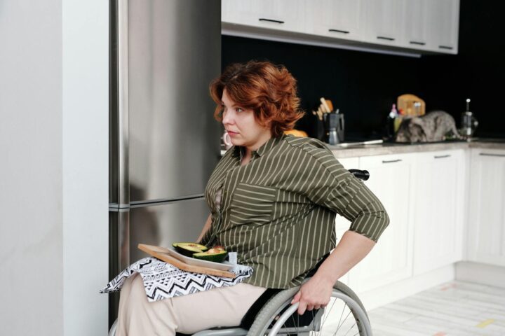 woman sitting on a wheelchair in a kitchen