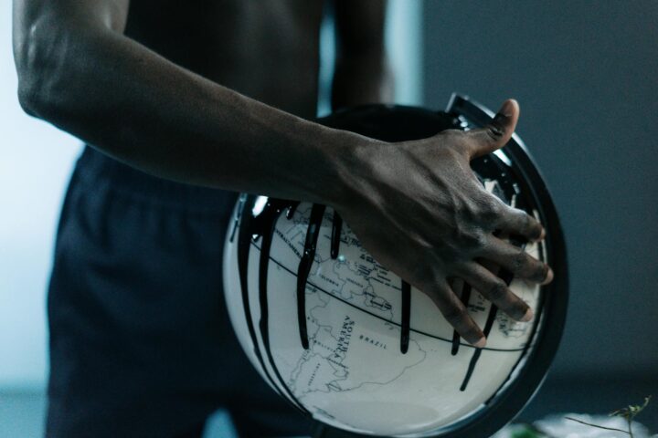 globe flooded with black goo and covered by a hand