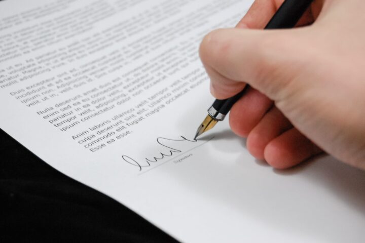 person signing in documentation paper