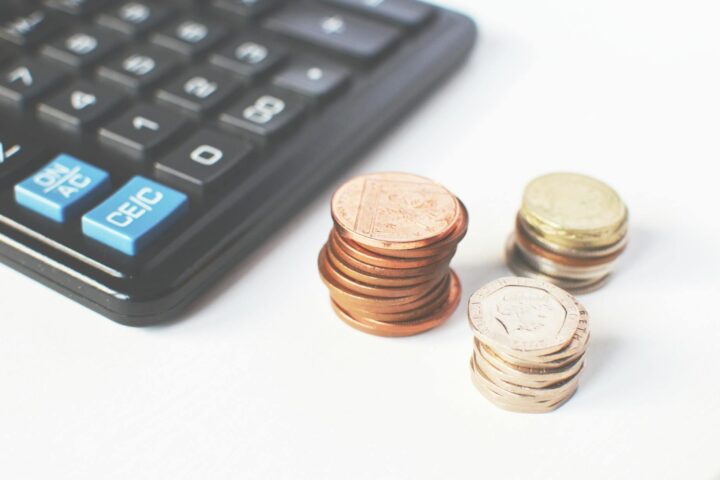 gold colored coins near calculator