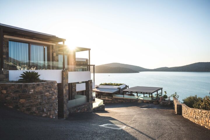 sun piercing of brown concrete house near sea