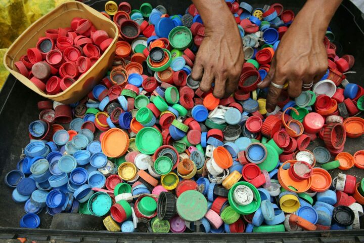 person hands on assorted color plastic lid lot