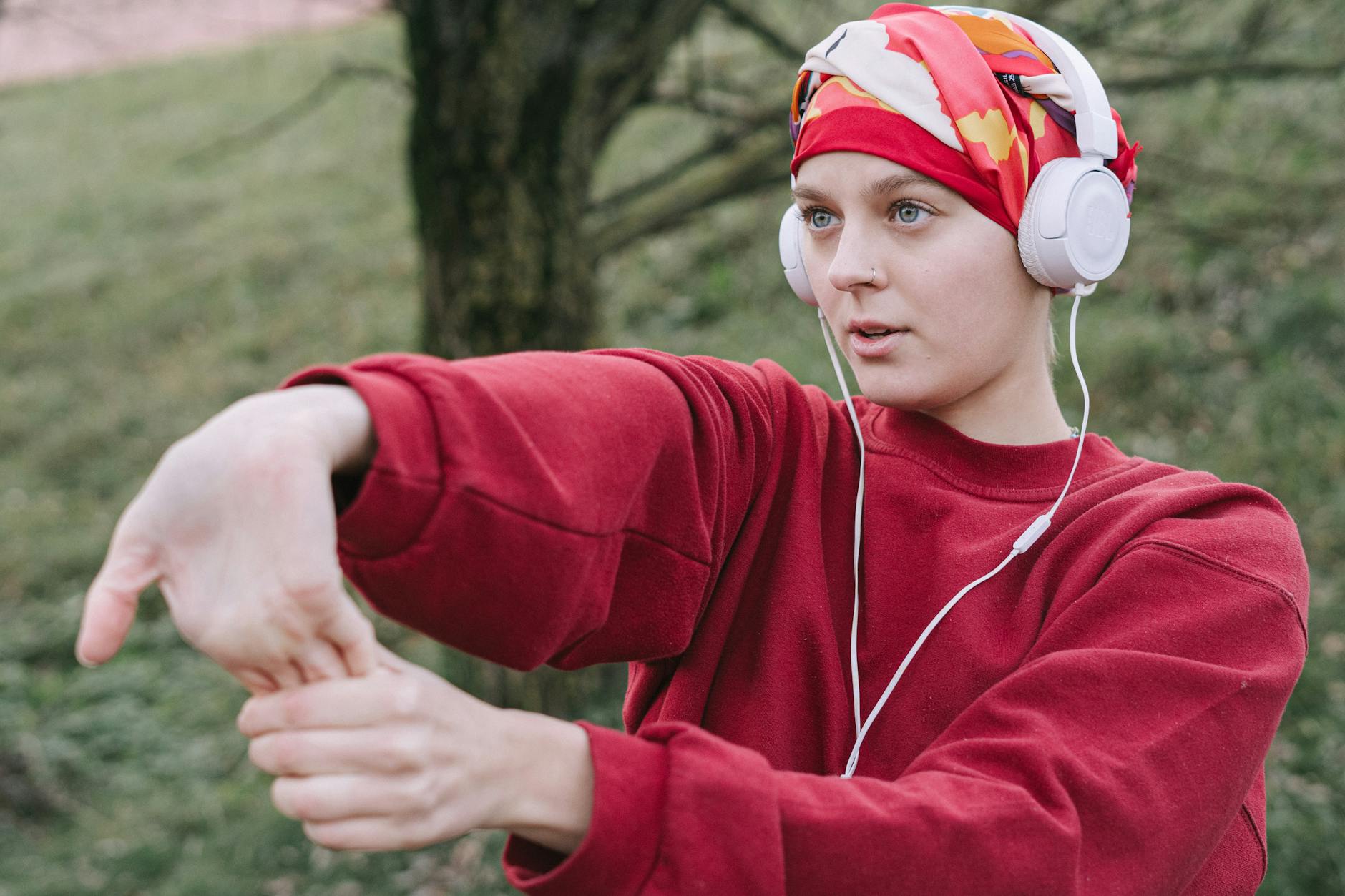 woman wearing white headphones and red sweater